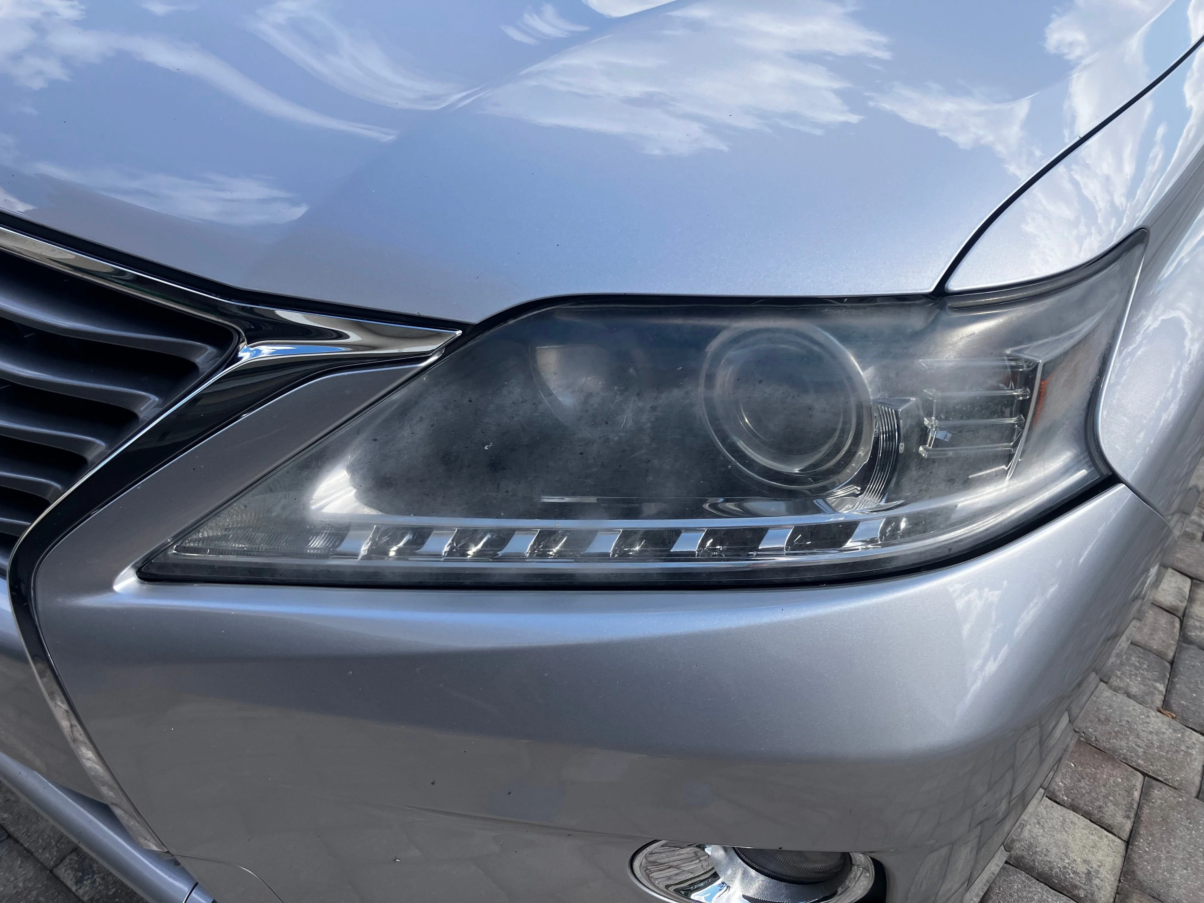 Headlight Restoration Before Cocoa Beach Heavy sun oxidation and yellow cloudiness on a car headlight lens before mobile restoration service in Cocoa Beach.